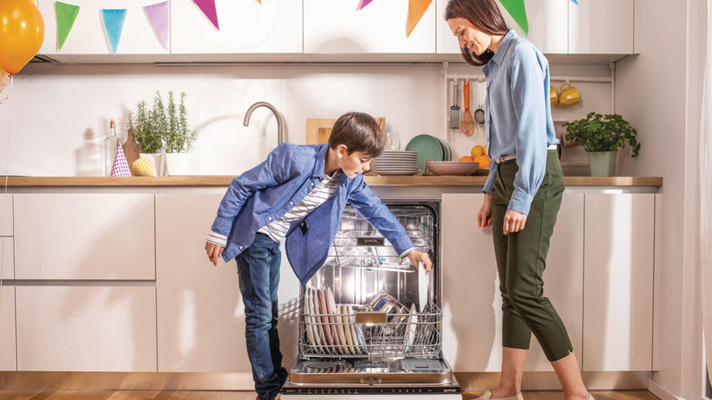 Mom and son doing dishes in a Gorenje UltraClean dishwasher.