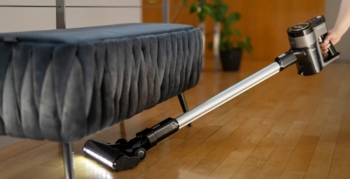 Person mit Staubsauger ohne Kabel beim Staubsaugen