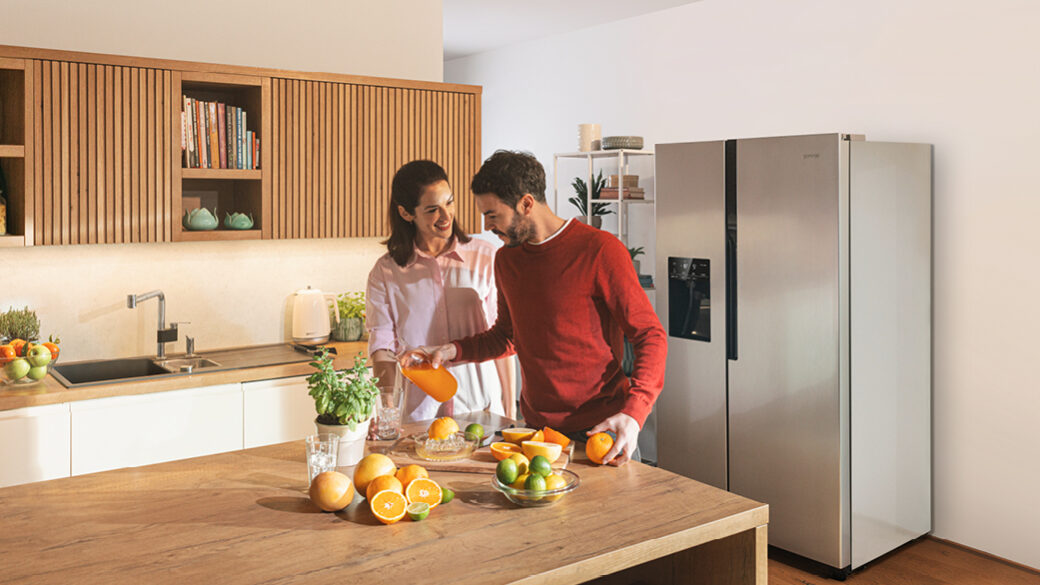 Žena a muž vaří v kuchyni před chladničkou Gorenje.