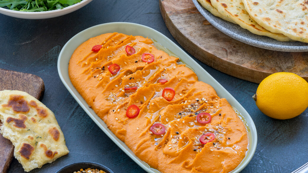 red pepper hummus on neutral background