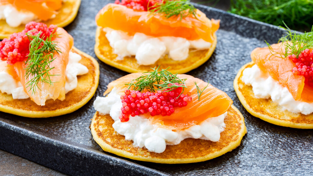 Plated blinis with cottage cheese and salmon