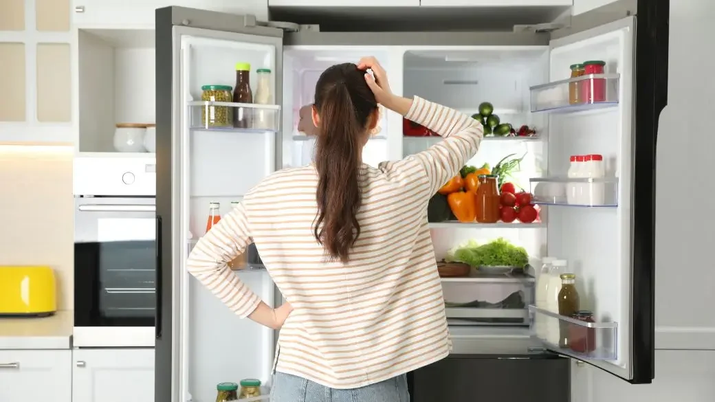 Frau am offenen Kühlschrank