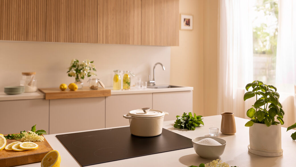 Gorenje G800 Matt Hob in a modern kitchen interior, surrounded by fresh lemons, herbs, and a ceramic cooking pot.