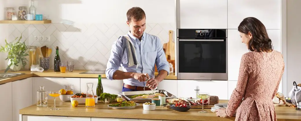 Zwei Personen in einer Küche beim Kochen.