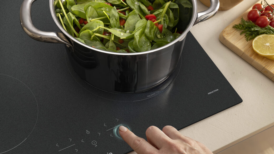 Modern induction hob with a large cooking pan placed on the BigZone cooking area, showing even heat distribution and efficient kitchen design.